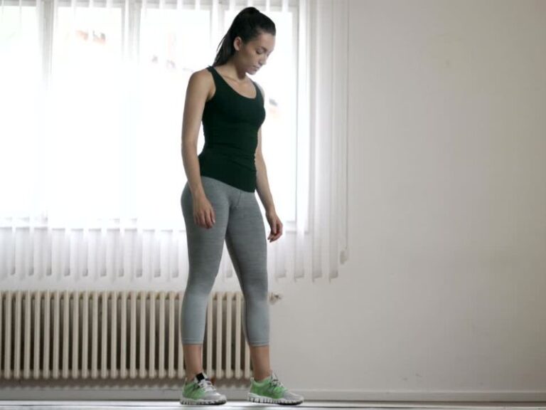 Devojka trenira u kući, obučena u sportsku opremu