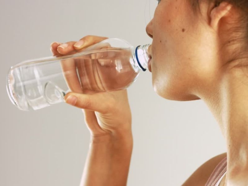Devojka pije vodu iz plastične flašice